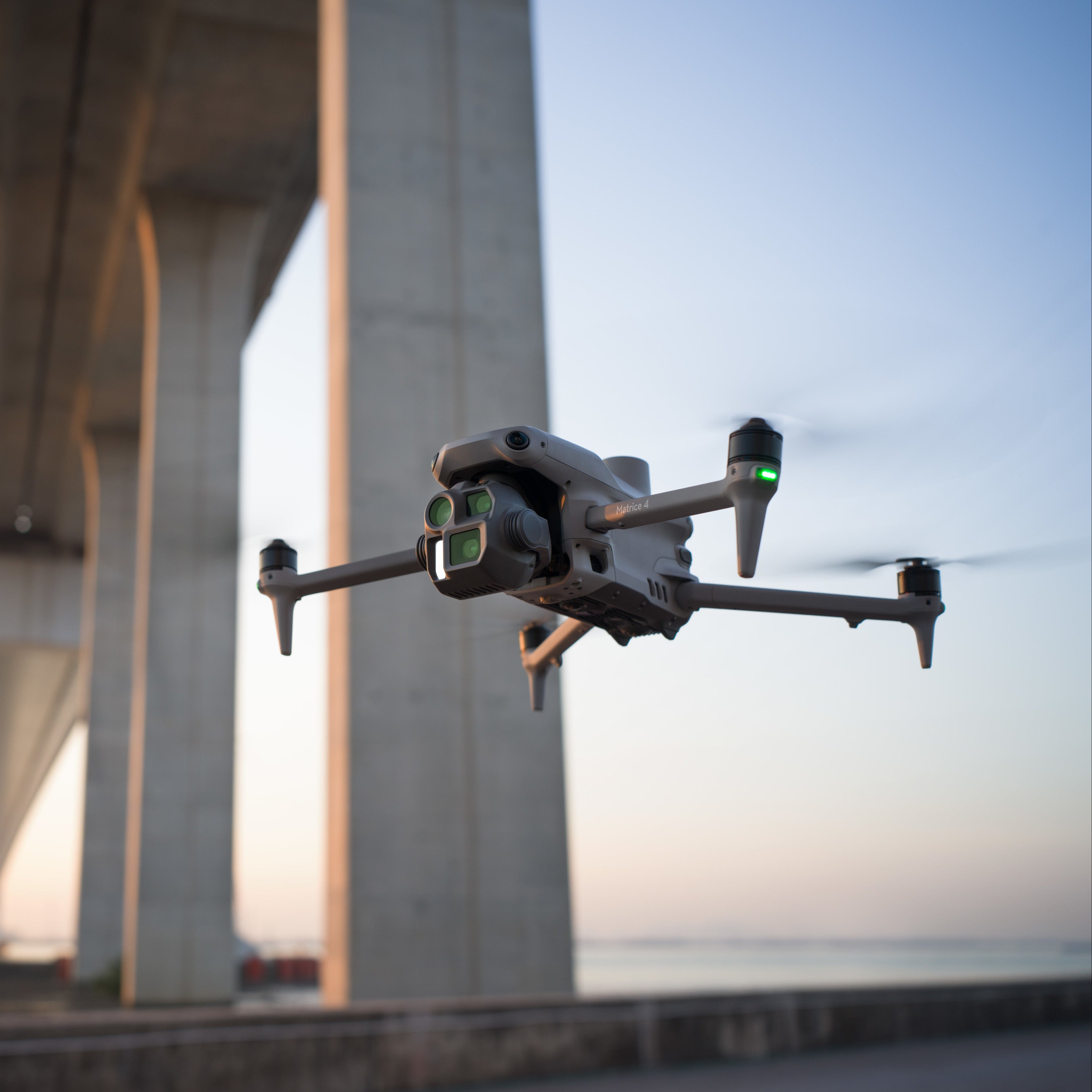 Drone flying in front of a concrete structure with a blurred background